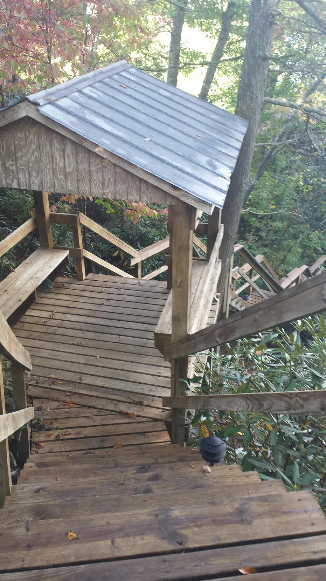 Metal roofed shelter over wooden steps on a wooded walkway — Skylight Repair & Installation work by our crew in Southborough