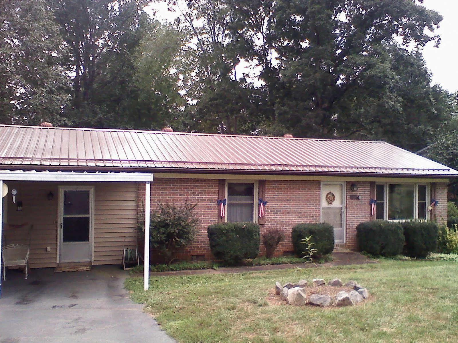 Bronze metal roof and carport on a brick ranch home — Roof Repair work by our crew in Southborough